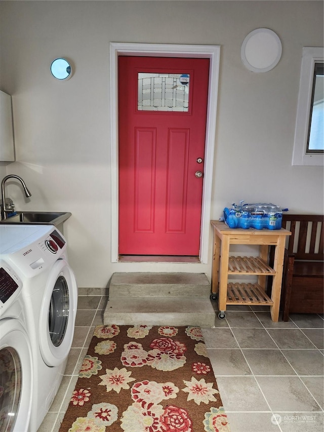 clothes washing area featuring tile patterned floors, independent washer and dryer, and sink