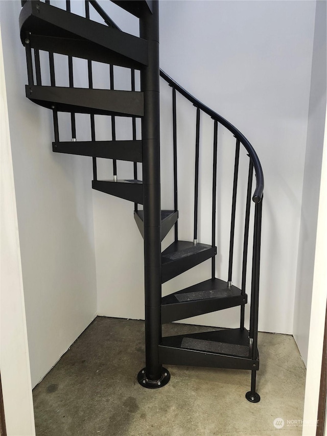 staircase featuring concrete floors