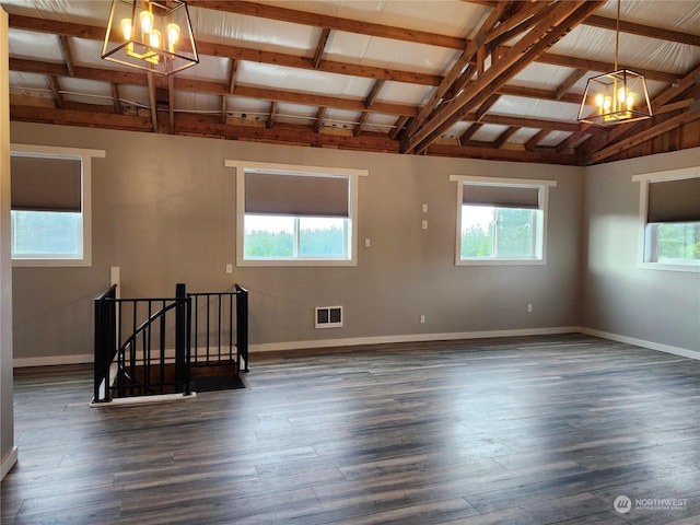 spare room with vaulted ceiling with beams, a wealth of natural light, and an inviting chandelier