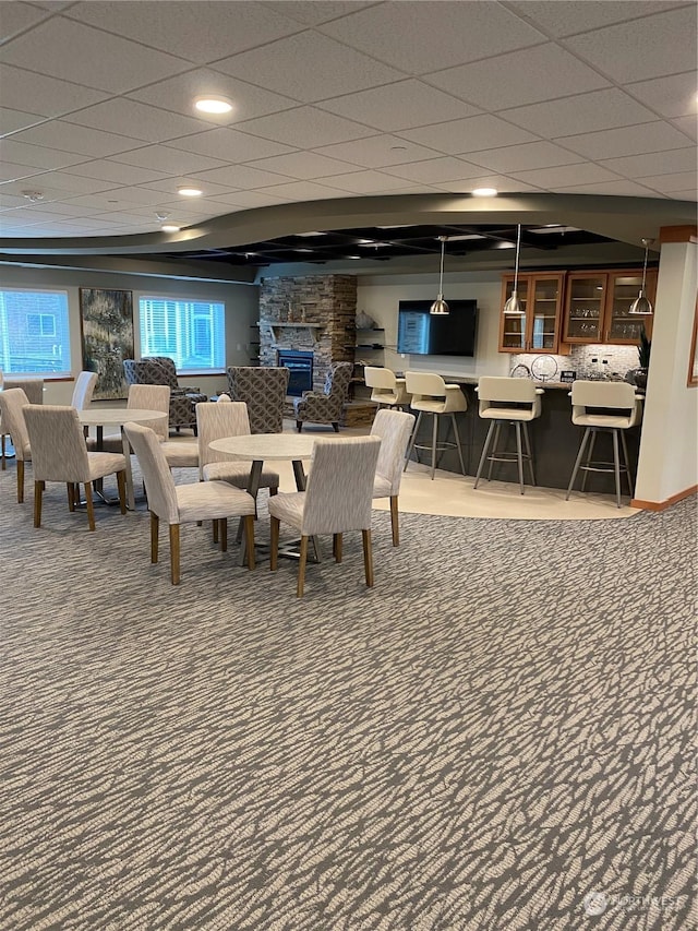 carpeted dining area with indoor bar and a fireplace