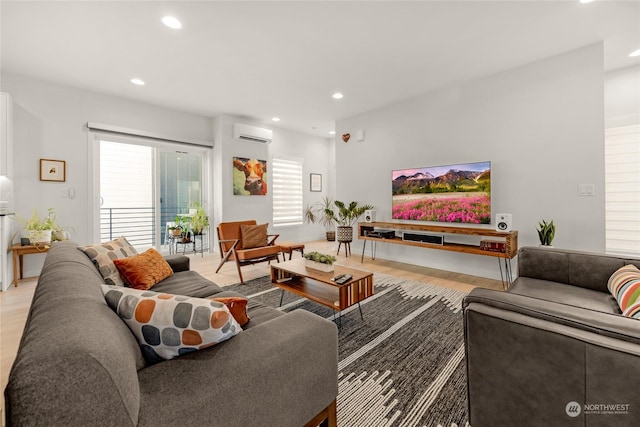 living room featuring light wood-type flooring and a wall unit AC