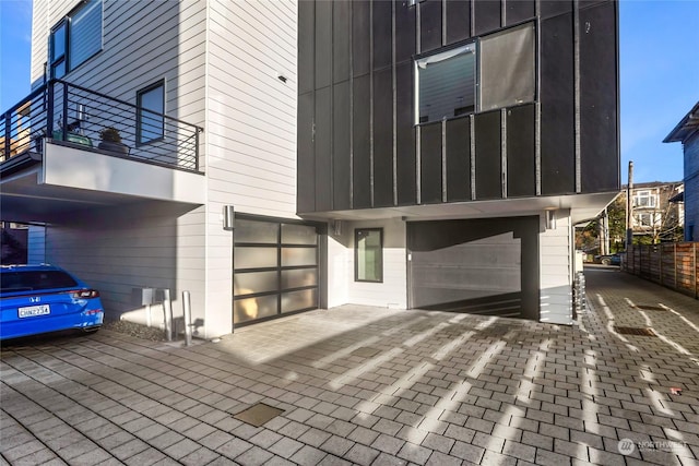 view of side of home with a balcony and a garage