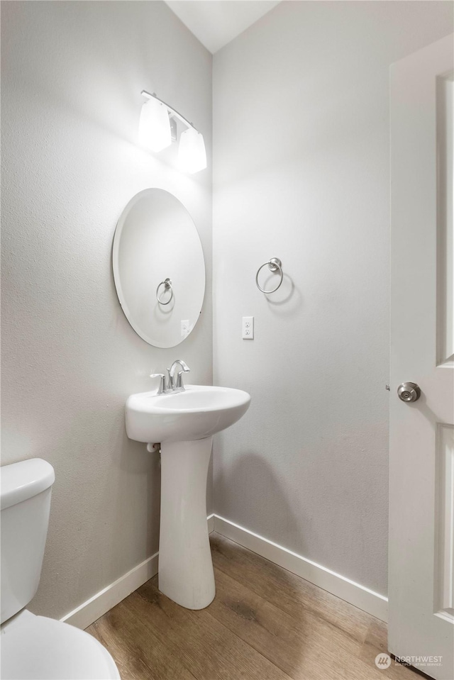 bathroom with wood-type flooring and toilet