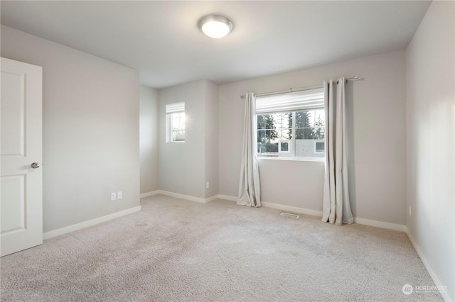 spare room featuring light colored carpet