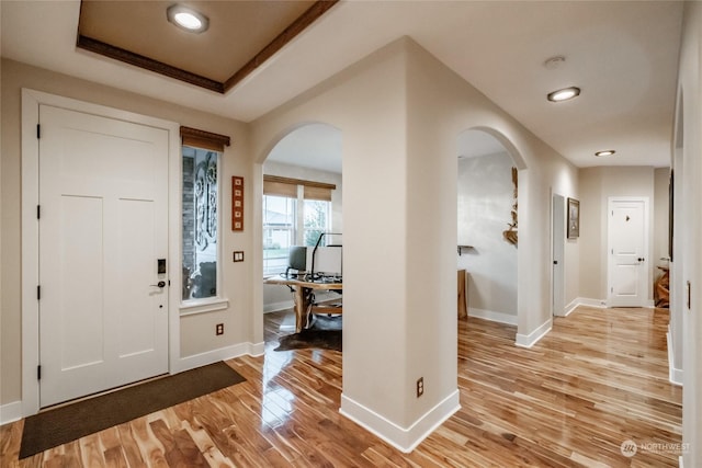 entrance foyer with a raised ceiling and light hardwood / wood-style flooring