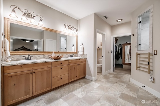 bathroom featuring a shower, vanity, and toilet