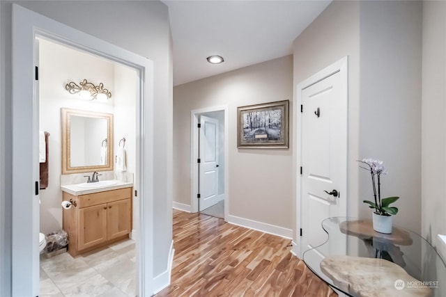 hall with sink and light hardwood / wood-style flooring