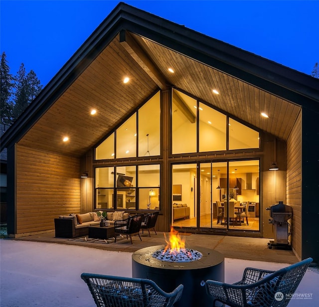 back of house featuring a patio area and an outdoor living space with a fire pit