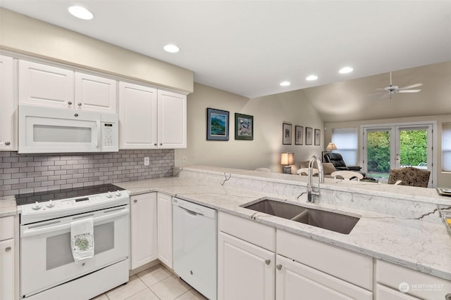 kitchen with vaulted ceiling, white cabinetry, sink, and white appliances