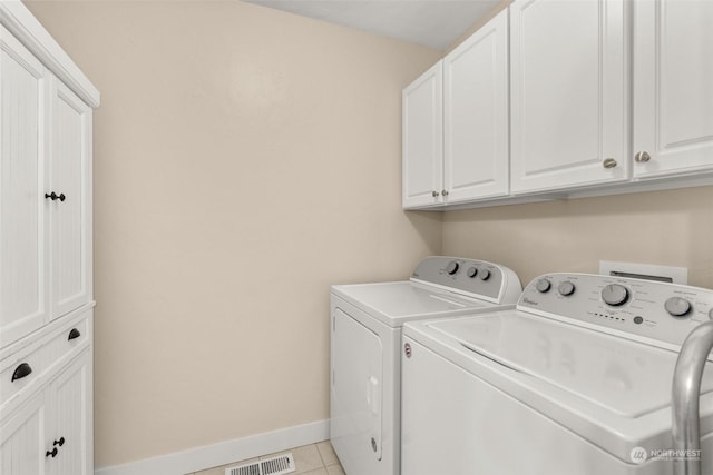 laundry area with separate washer and dryer, light tile patterned flooring, and cabinets