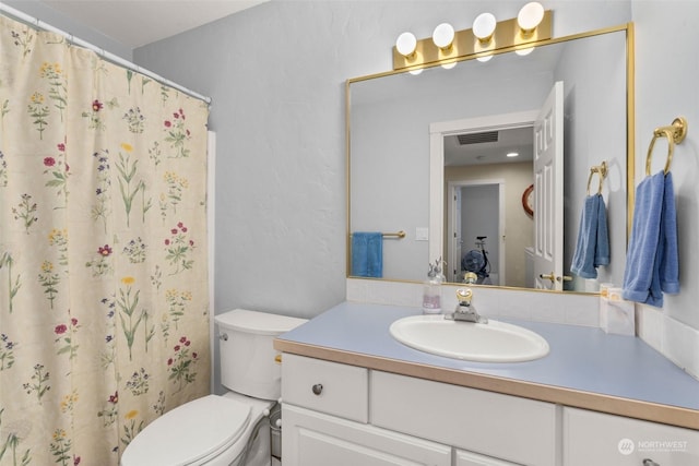 bathroom with vanity, toilet, and walk in shower