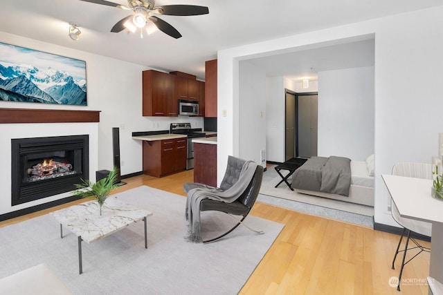 living room featuring light wood-type flooring and ceiling fan