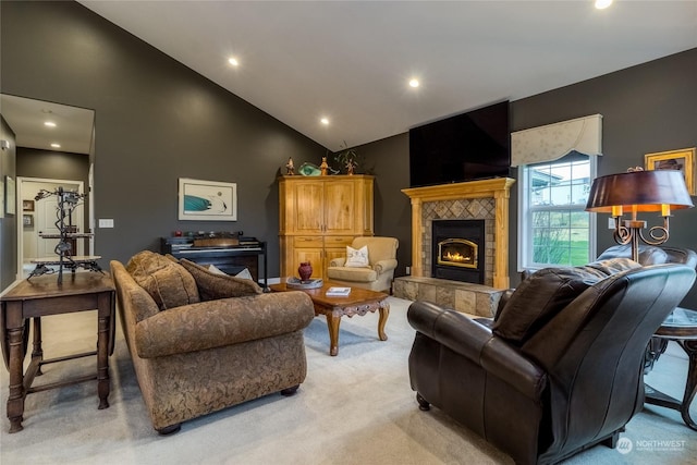 carpeted living room with a tiled fireplace and high vaulted ceiling