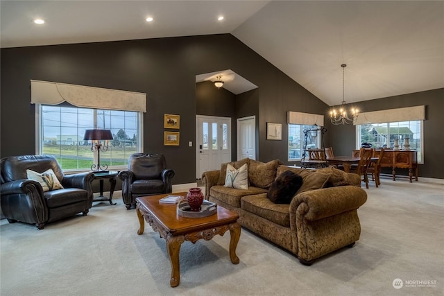 living room featuring high vaulted ceiling, light colored carpet, a healthy amount of sunlight, and a notable chandelier