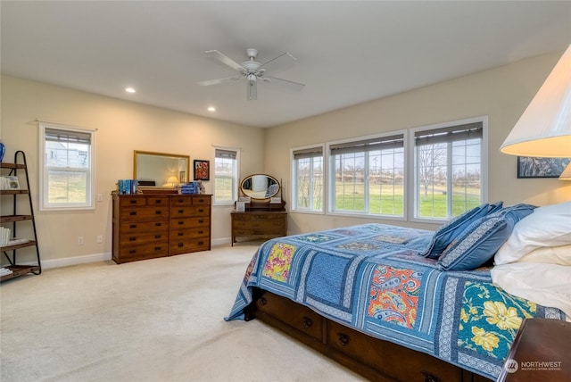 carpeted bedroom featuring multiple windows and ceiling fan