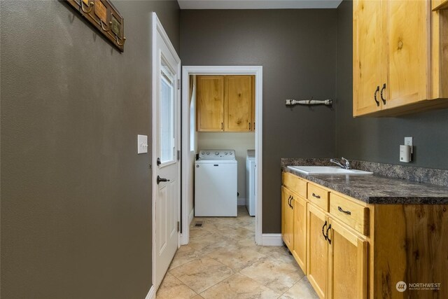 washroom with washer and dryer, cabinets, and sink