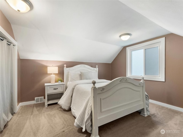 bedroom featuring light carpet and vaulted ceiling