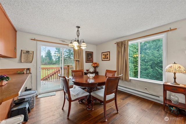 dining room with a textured ceiling, dark hardwood / wood-style flooring, a baseboard heating unit, and a notable chandelier