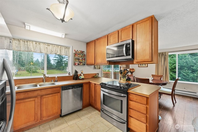 kitchen with sink, plenty of natural light, light hardwood / wood-style floors, and appliances with stainless steel finishes