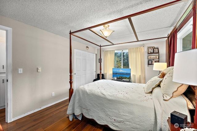 bedroom featuring dark hardwood / wood-style flooring and a textured ceiling