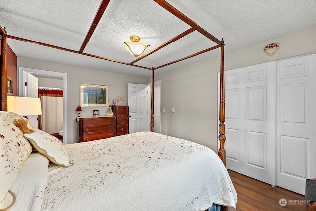 bedroom featuring a textured ceiling, dark hardwood / wood-style flooring, and a closet