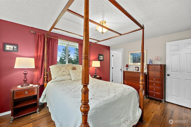 bedroom with a textured ceiling and dark wood-type flooring