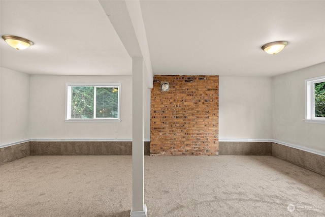 spare room with carpet flooring and brick wall