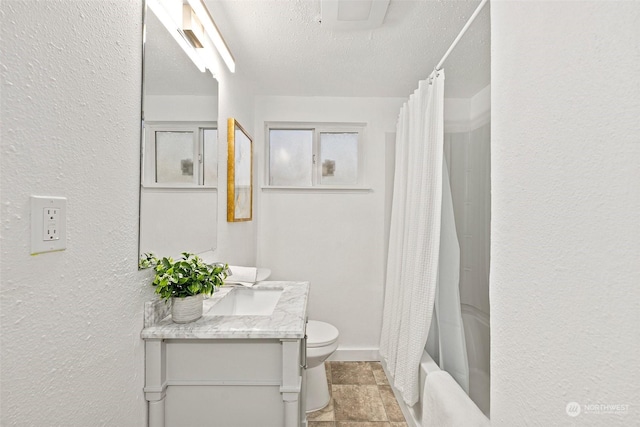 full bathroom featuring toilet, a textured ceiling, shower / tub combo with curtain, and vanity