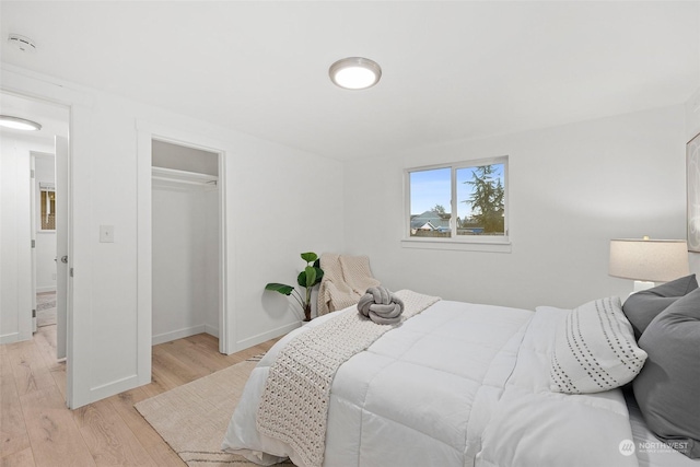 bedroom with light hardwood / wood-style floors and a closet