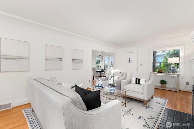 living room with plenty of natural light, visible vents, and light wood finished floors