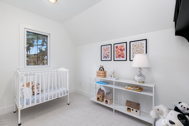 carpeted bedroom featuring lofted ceiling, a nursery area, and baseboards