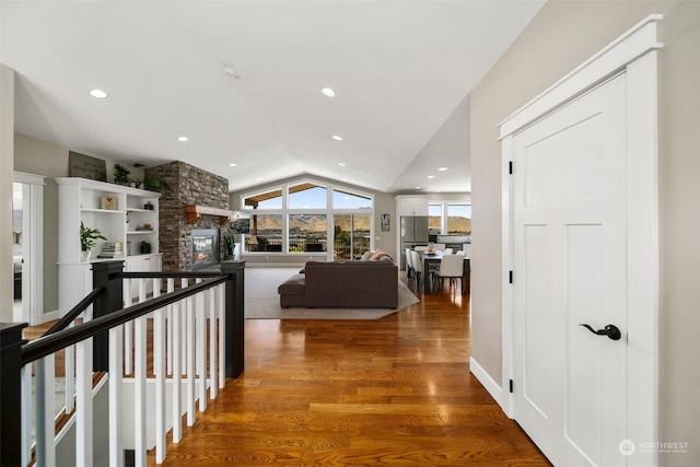 hallway featuring wood-type flooring and vaulted ceiling