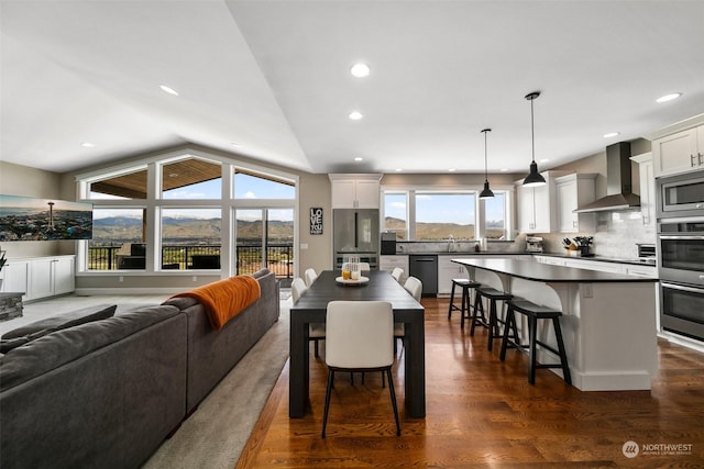 dining room featuring dark hardwood / wood-style flooring, a healthy amount of sunlight, vaulted ceiling, and sink