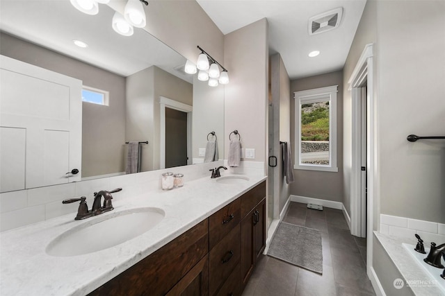 bathroom featuring vanity, tile patterned floors, and a bathing tub