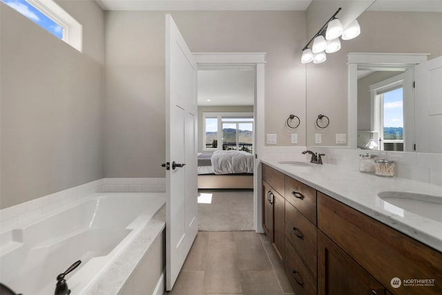 bathroom featuring tile patterned flooring, vanity, and a tub