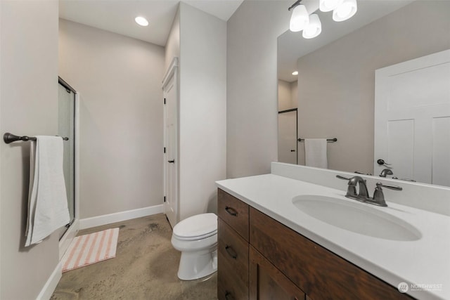 bathroom featuring a shower with door, vanity, and toilet