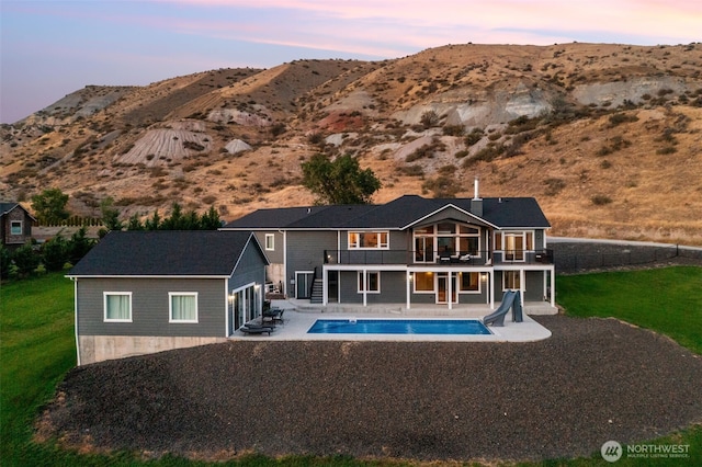 11 Holcomb Dr, East Wenatchee, WA 98802 - rear view of house featuring a patio, a lawn, a balcony, an outdoor pool, and a mountain view