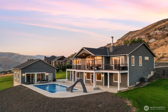 11 Holcomb Dr, East Wenatchee, WA 98802 - back of property at dusk with a patio, a mountain view, cooling unit, and a balcony