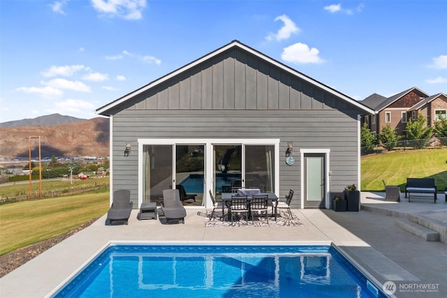 11 Holcomb Dr, East Wenatchee, WA 98802 - back of house with a mountain view, a patio area, board and batten siding, and an outdoor pool