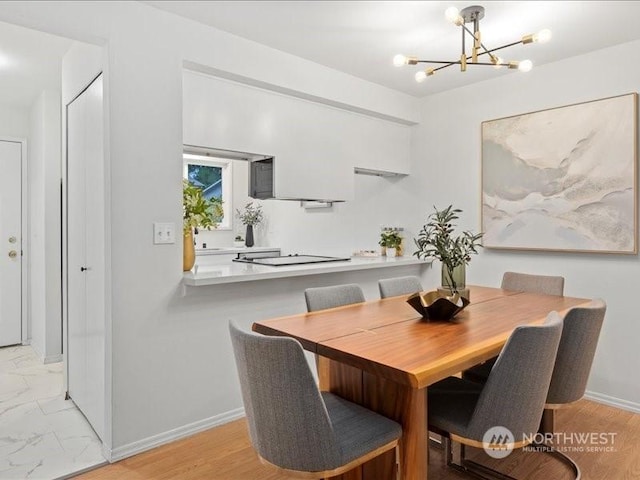 dining area featuring light hardwood / wood-style flooring and a notable chandelier