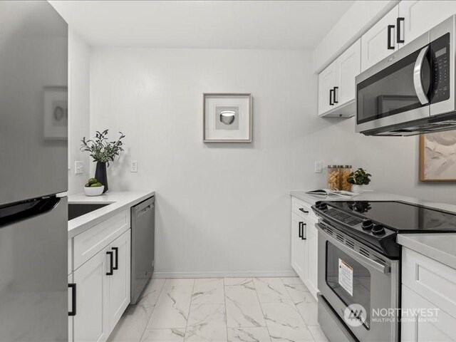 kitchen with white cabinets and appliances with stainless steel finishes