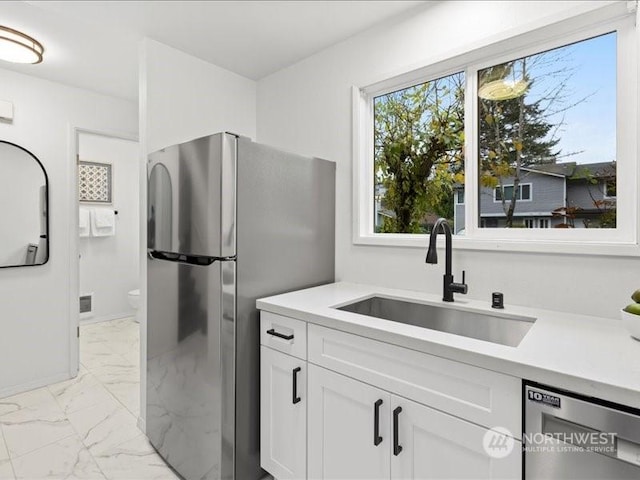 kitchen featuring white cabinets, appliances with stainless steel finishes, and sink