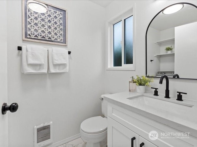 bathroom featuring vanity, heating unit, and toilet