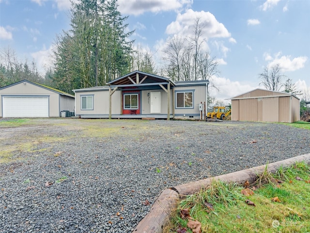 view of front of property featuring central AC, a garage, and an outdoor structure