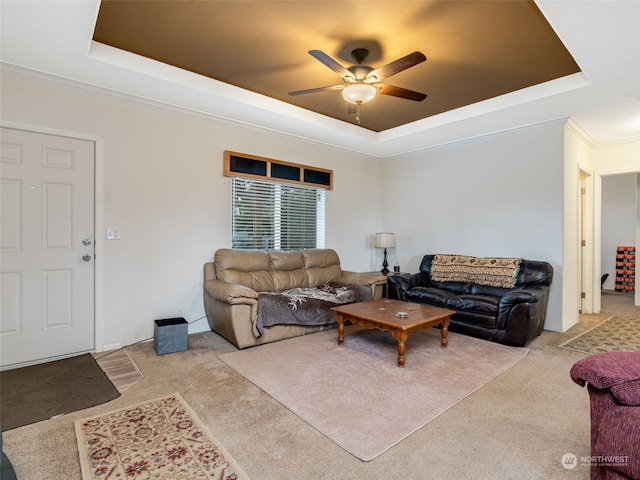 living room with a raised ceiling, light carpet, and ceiling fan