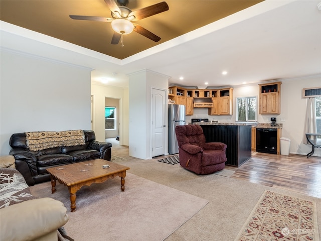 living room with light wood-type flooring, ceiling fan, and crown molding