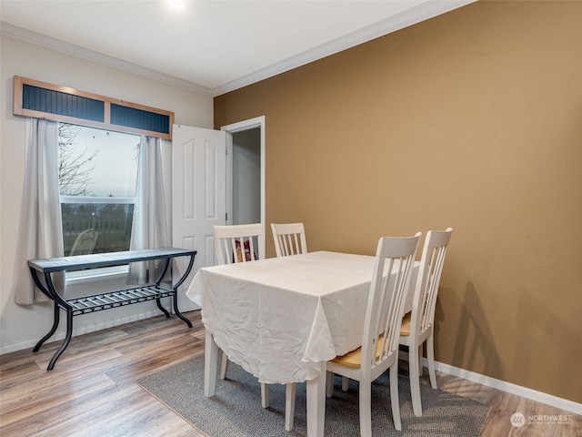 dining area with ornamental molding and hardwood / wood-style flooring