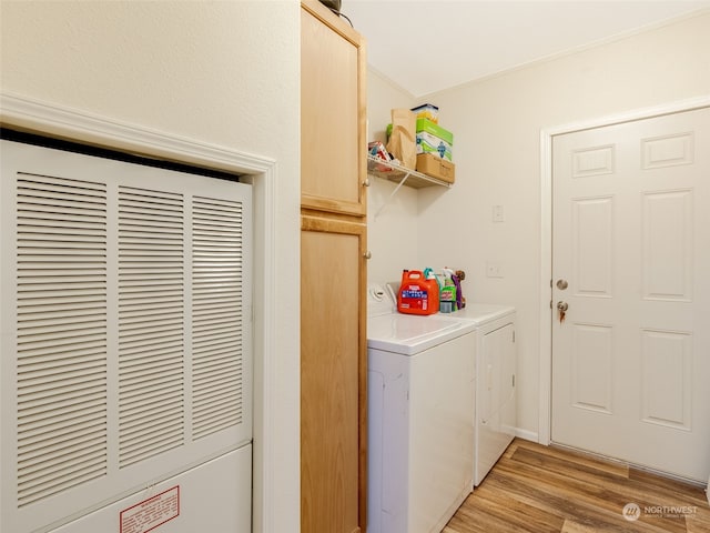 washroom featuring washer and clothes dryer, cabinets, and light hardwood / wood-style flooring