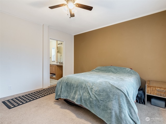 carpeted bedroom with ensuite bath, ceiling fan, and ornamental molding