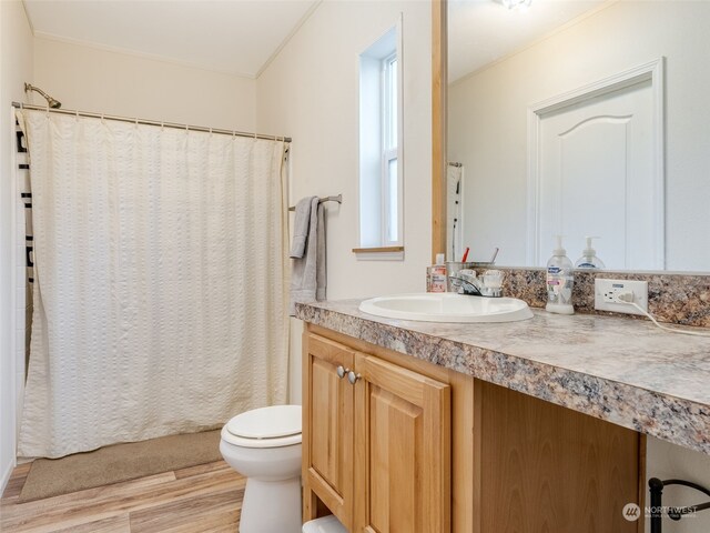 bathroom with hardwood / wood-style floors, vanity, toilet, and crown molding